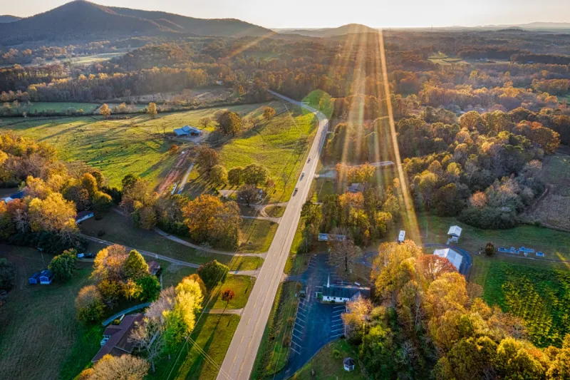 Aerial shot of backlit road in Georgia Mountains during the sunset in the Fall